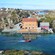 A boat cruising through a channel past a hotel on the island of Røvær